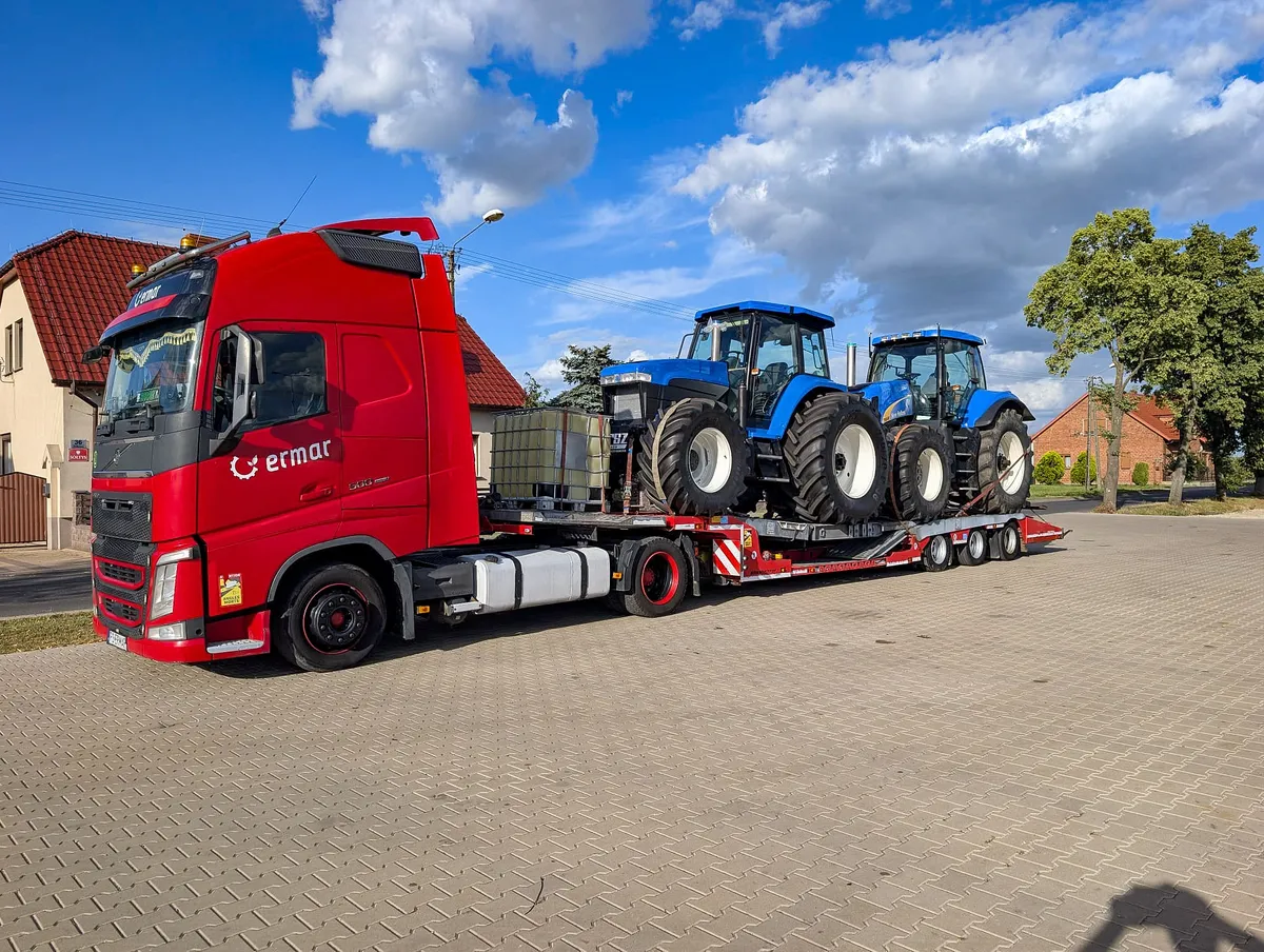 Dwa ciągniki New Holland na naczepie niskopodwoziowej ERMAR gotowe do transportu